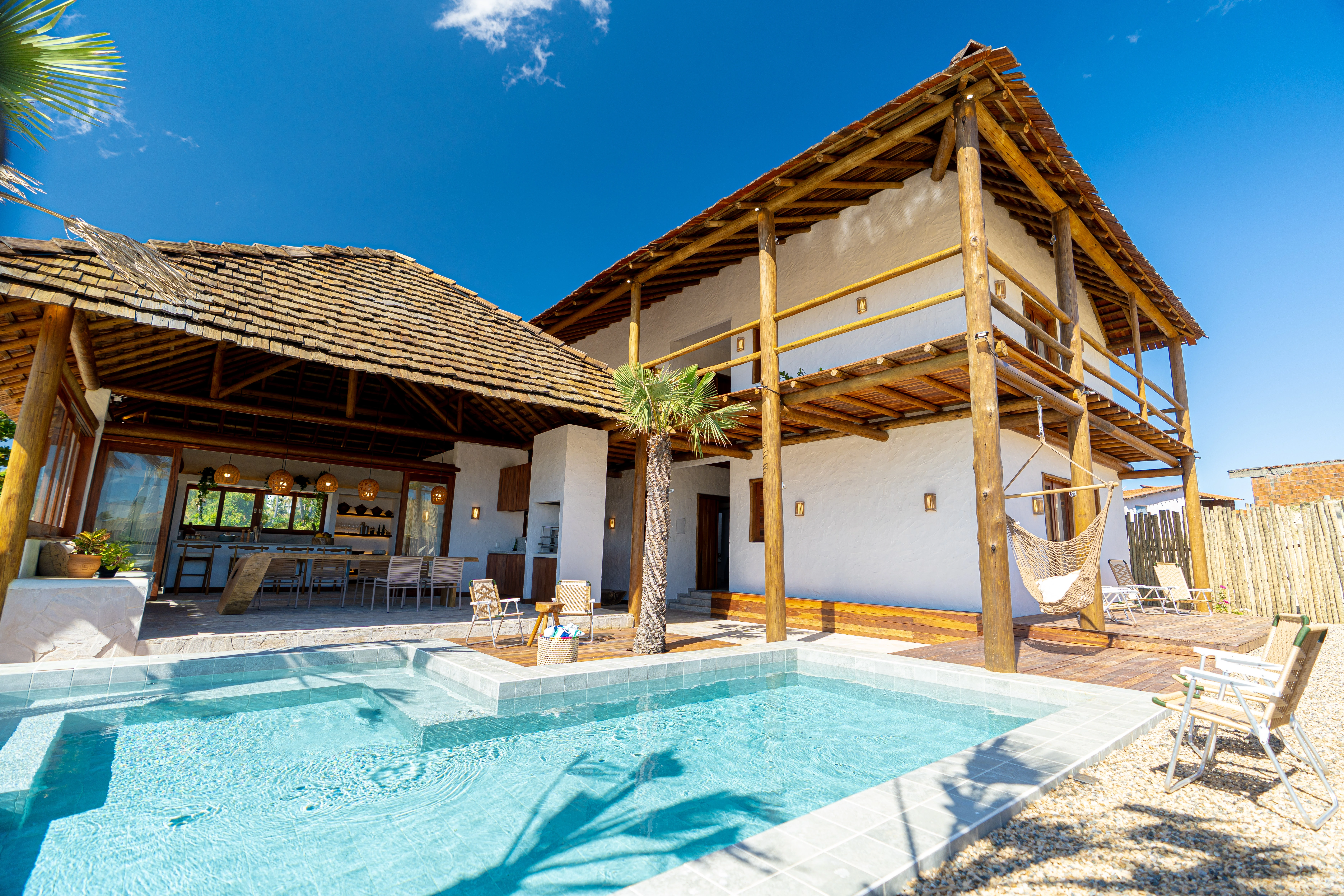 Área externa da Casa Areia com piscina e arquitetura em madeira