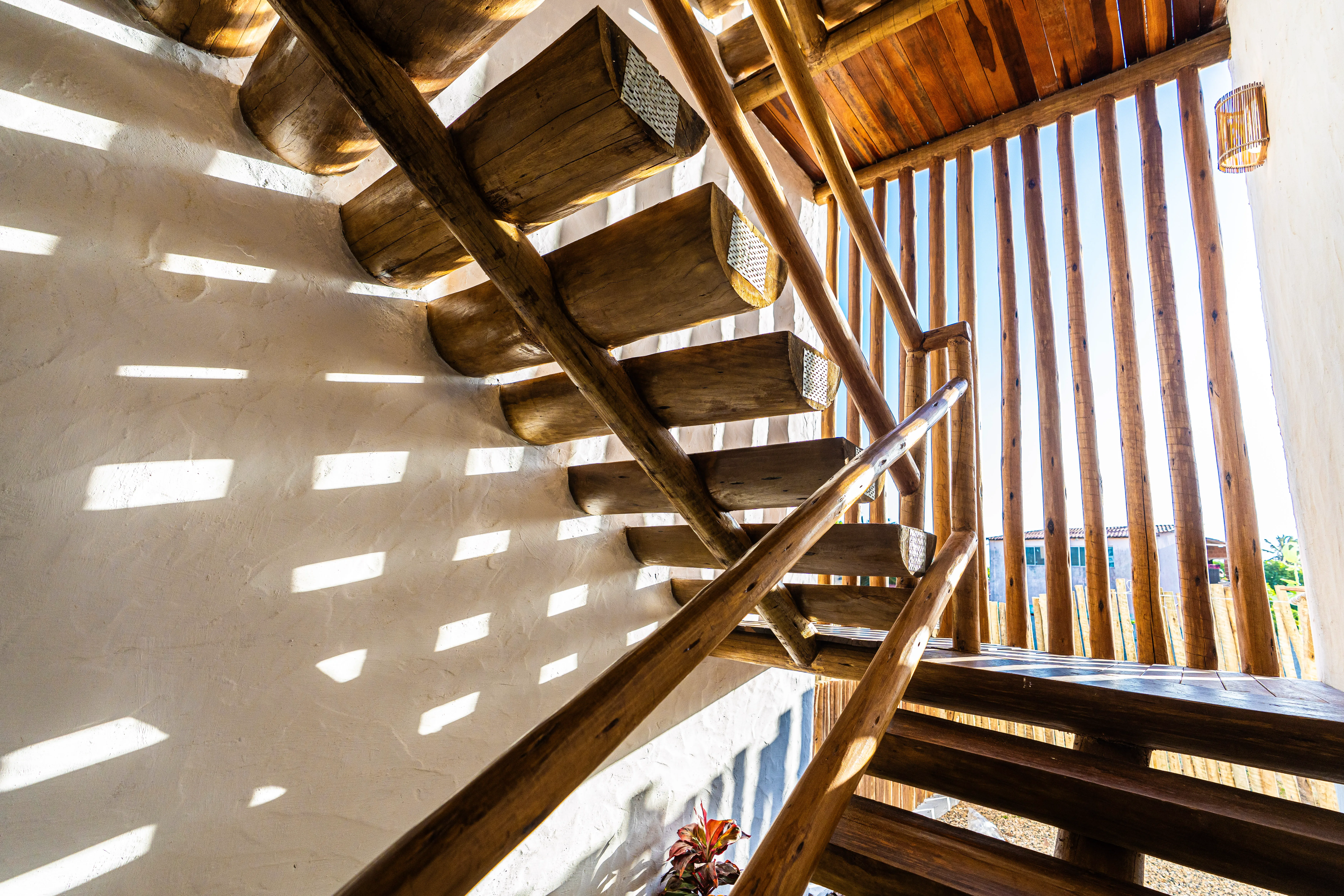 Escada em madeira da Casa Areia com entrada de luz natural