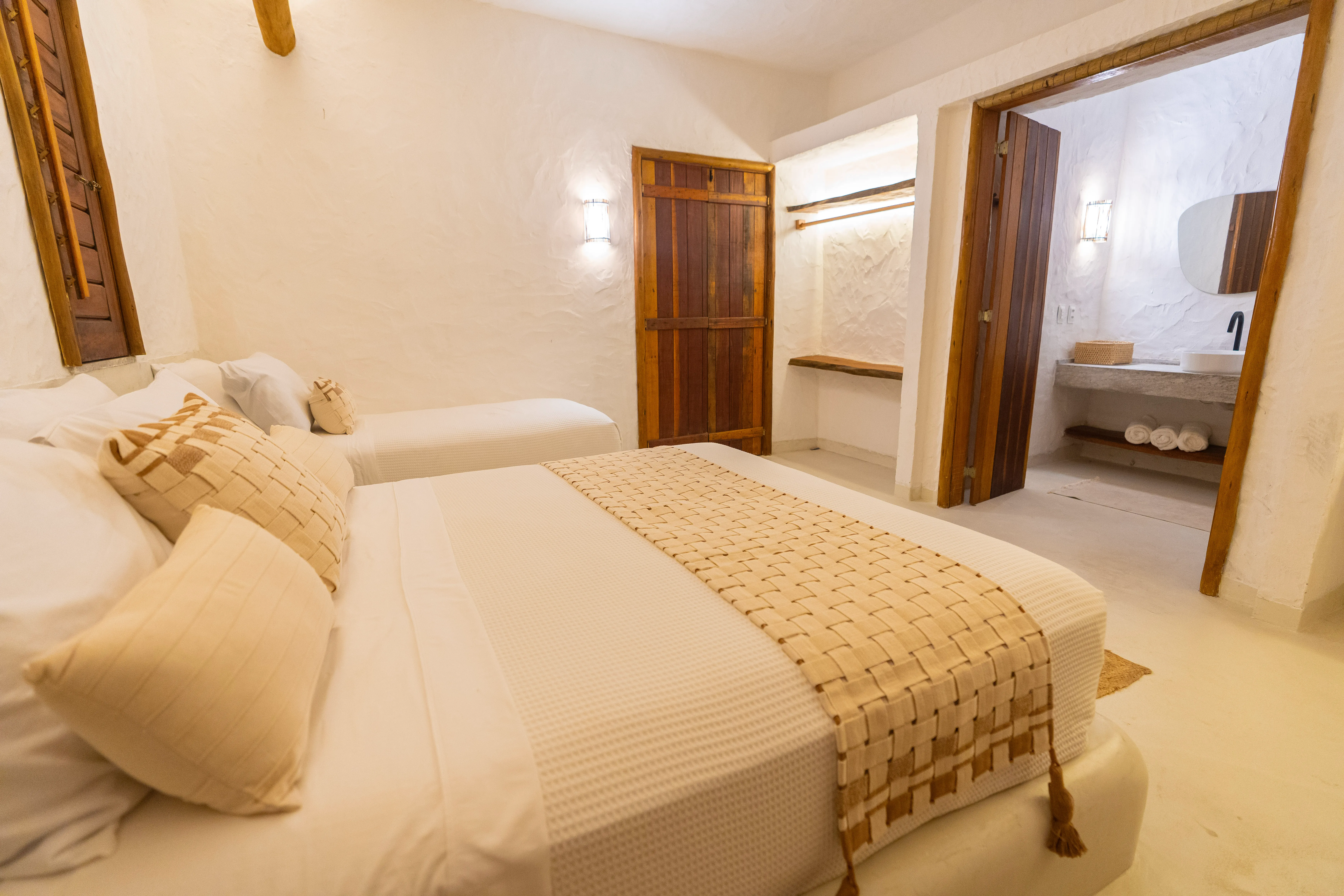 Quarto da Casa Areia em tons claros com acabamento em madeira